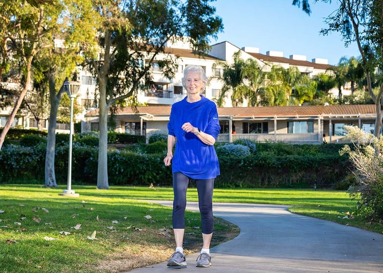 senior woman walking outside on a path